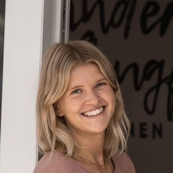 Blonde Frau, stehend am Fenster, im Hintegrund Kindernest Pflugfelden